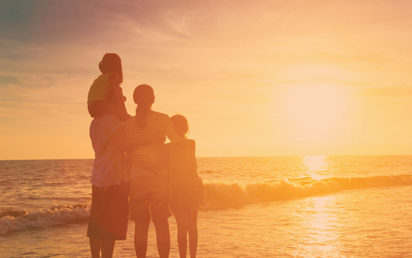Family on a beach, enjoying the sunset